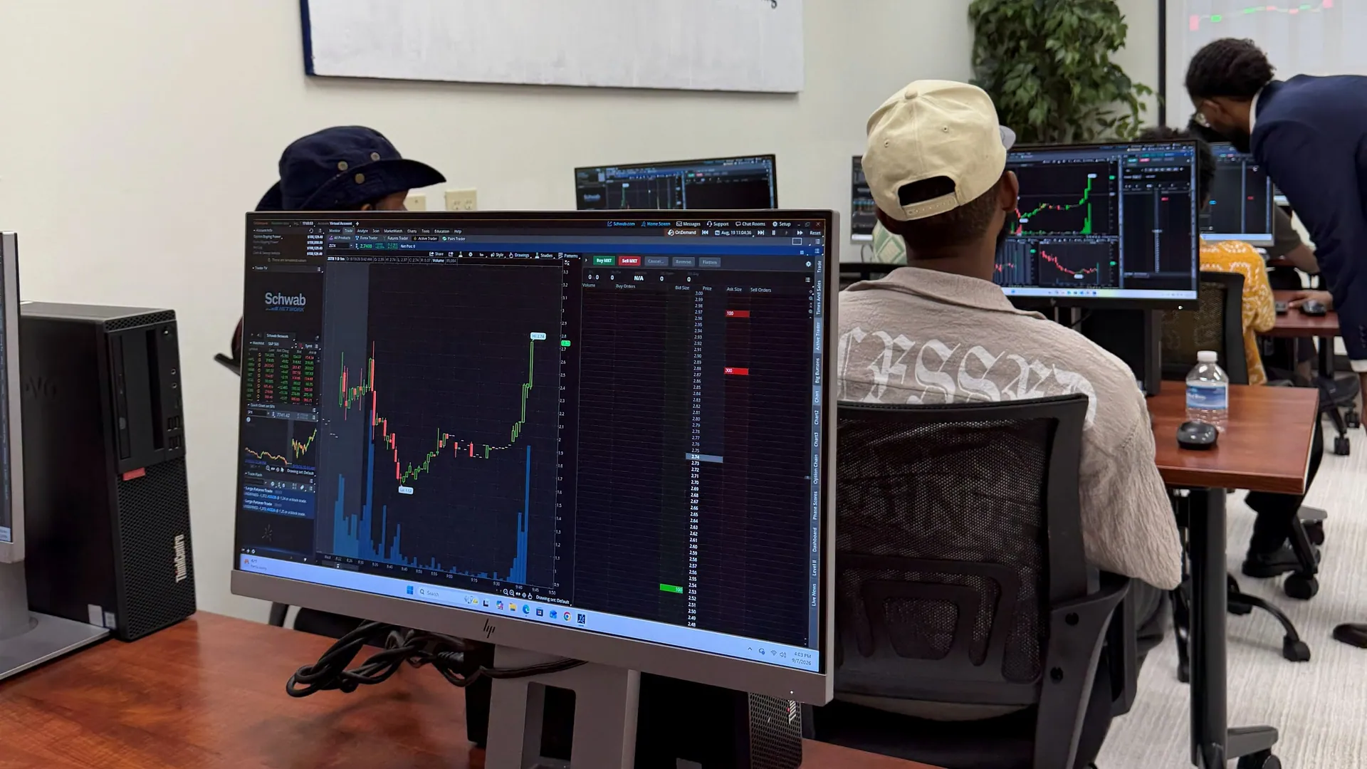 A MAAL class: a Schwab chart on the screen up close, students at their stations behind it and the instructor leaning in to help
